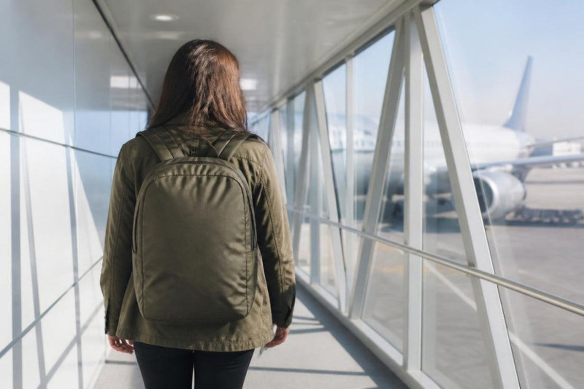 Voyageuse avec un sac à dos cabine sur une passerelle d'embarquement