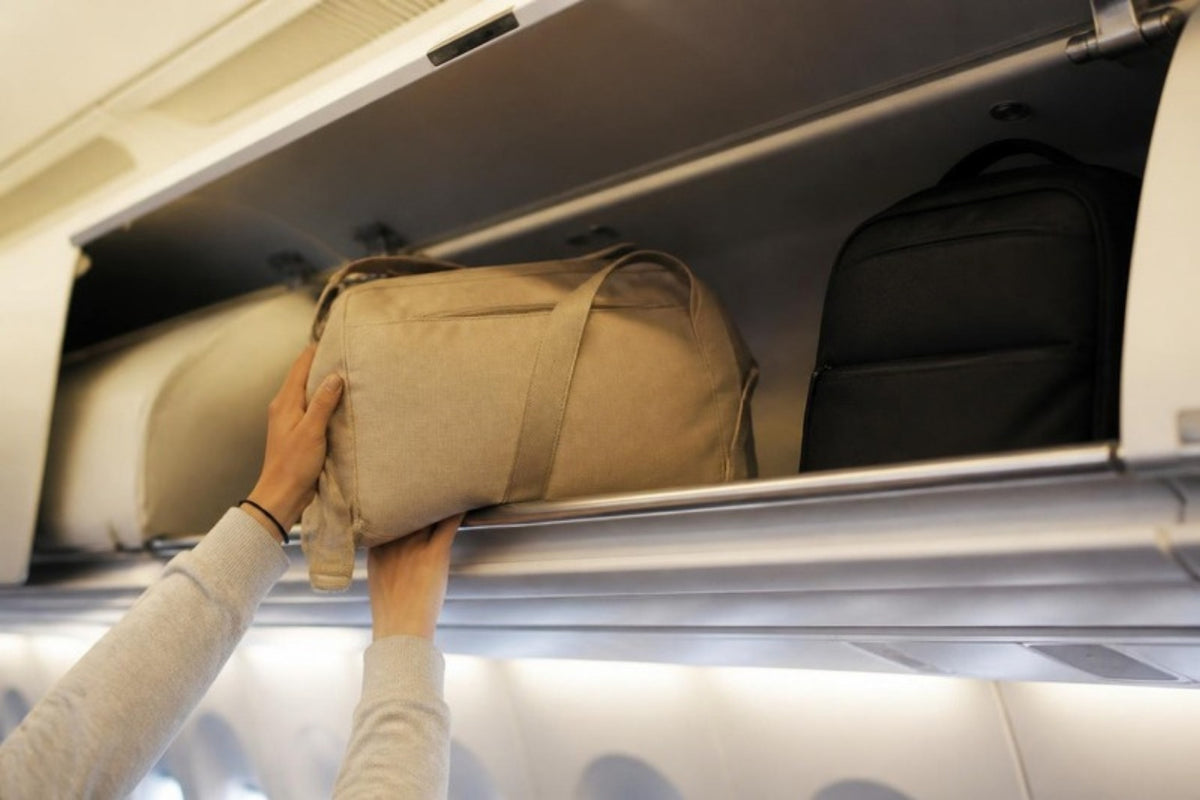 Sac de voyage rangé dans le coffre à bagages d'une cabine d'avion