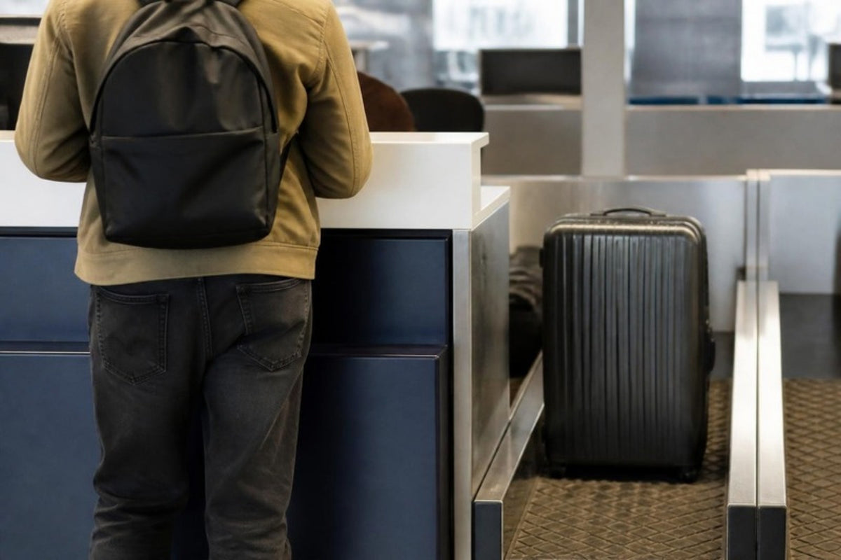 Valise enregistrée en soute sur le tapis et sac à dos gardé en cabine par le voyageur