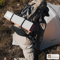 Voyageur avec sac à dos de voyage 70 L et matelas attaché, près d'une tente