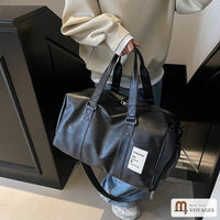 Sac de voyage noir Milano porté à la main, vu de côté