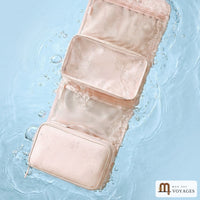 Trousse de toilette Lagune rose pêche dépliée sur l'eau avec des gouttes
