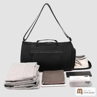 Sac polochon Zénith noir avec vêtements, tablette et accessoires de voyage rangés devant