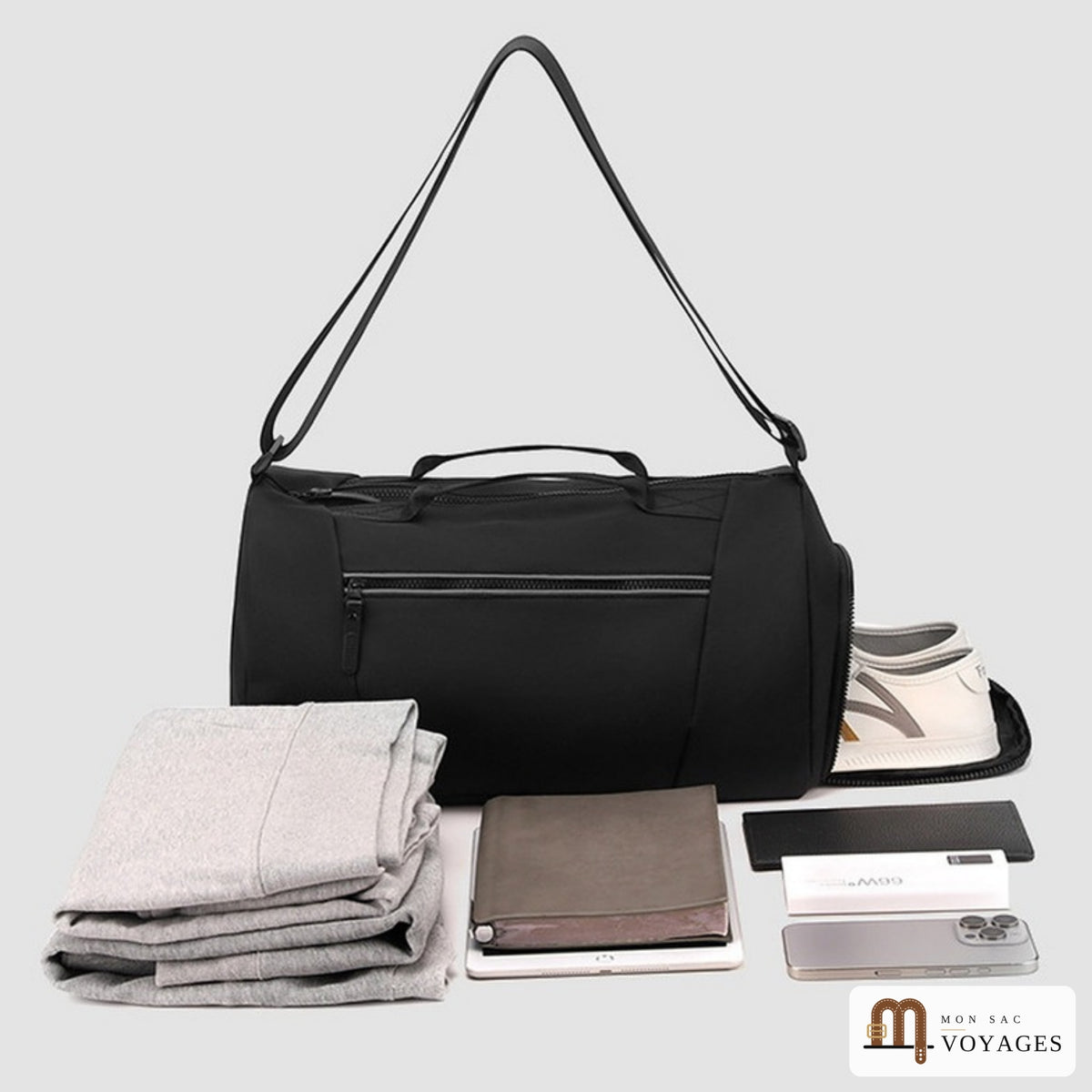 Sac polochon Zénith noir avec vêtements, tablette et accessoires de voyage rangés devant