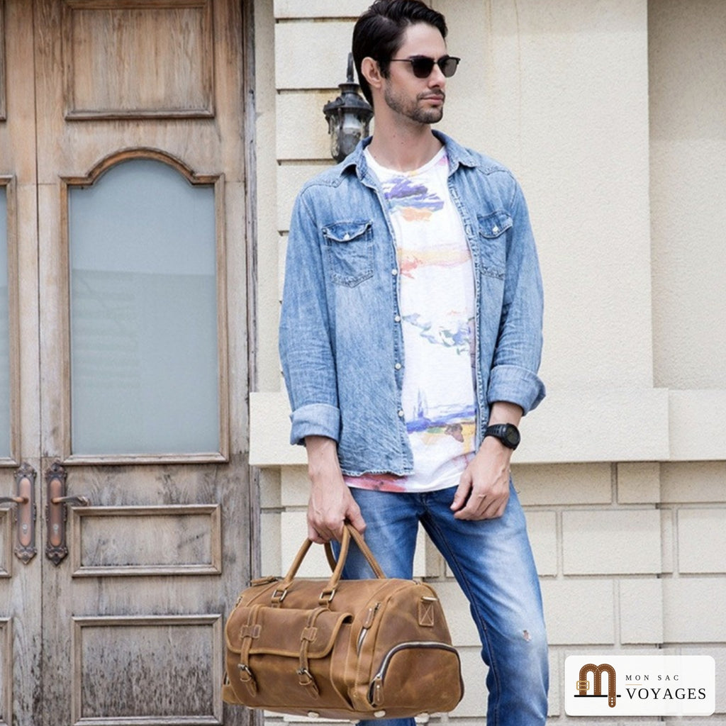 Homme portant un sac de voyage cuir vintage Cognac à la main